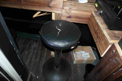 a black stool sitting in the corner of a room