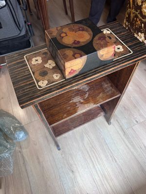 a small table with a wooden top and a drawer on it