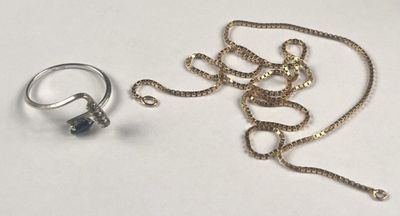 two rings and a chain on a white surface