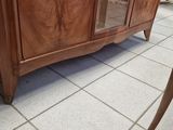 a wooden cabinet with a glass door in the middle of the room
