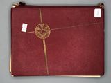 a red book with gold trim and a gold medallion on it
