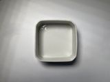 a small square dish on a table with a spoon