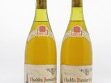 deux bouteilles de vin posées l'une à côté de l'autre sur une surface blanche