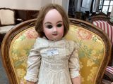 a doll that is sitting on a chair in a room