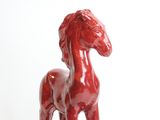 a red horse statue on a white surface