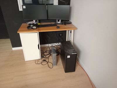 a desk with two monitors and a keyboard on it