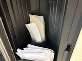 a metal cabinet with a bunch of papers inside of it