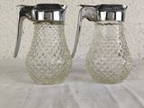 pair of clear glass salt and pepper shakers on a white table