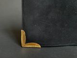 leather wallet with a gold clasp on a black surface
