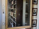 un miroir accroché au mur dans une pièce où sont accrochés des tableaux