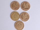four different types of gold coins sitting on top of a white surface