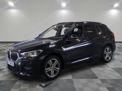 the bmw x1 is parked in a large room with a checkered floor