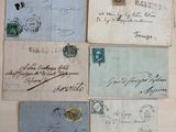 Plusieurs vieilles enveloppes sont disposées sur une surface blanche