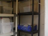 a black shelf with plastic containers and containers on it