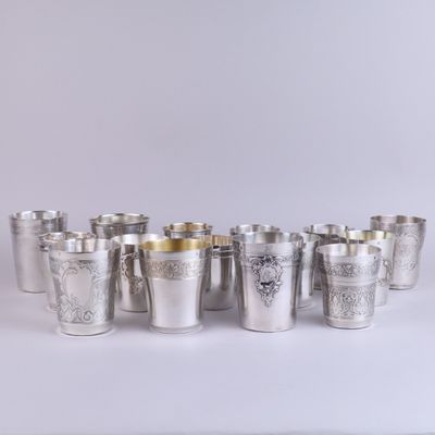 des verres à shot en argent alignés en rangée sur une surface blanche