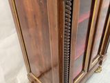 a wooden cabinet with a glass door on top of it