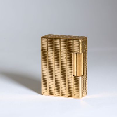 l'image d'un briquet doré posé sur une surface blanche