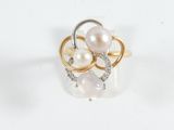 a ring with pearls and diamonds on it on a white surface
