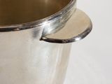 a silver pot with a spoon in it on a table
