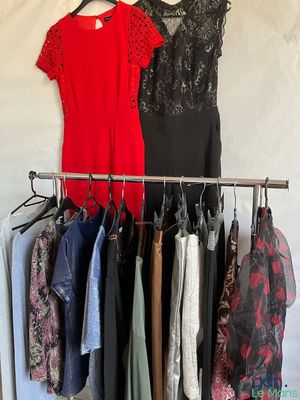 clothes hanging on a rack in front of a white wall