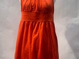 an orange dress on a mannequin display in a store window