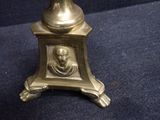 a gold vase with a picture of a man on it