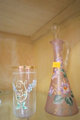 deux vases et un verre posés sur une étagère en verre