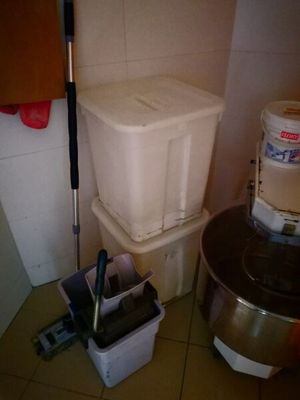 deux seaux et une serpillière posés par terre à côté des toilettes