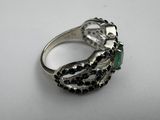 a close up of a silver ring with black and white stones