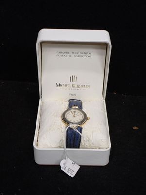 une boîte blanche contenant une montre, posée sur une surface noire