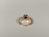 a close up of a gold ring with a green stone