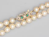 un gros plan sur un collier orné de perles et d'émeraudes
