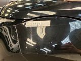 a black car with a sticker on it ' s hood