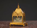 une horloge en or posée sur une table en marbre
