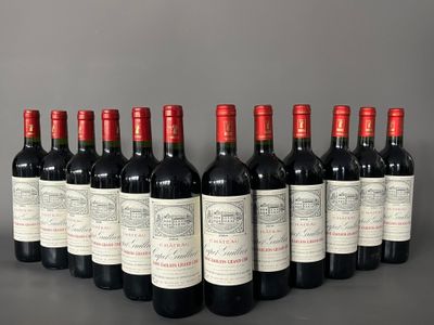 six bottles of red wine lined up in a row on a table