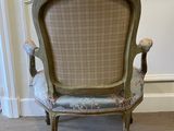 an old chair with a floral upholstered seat in a corner of a room