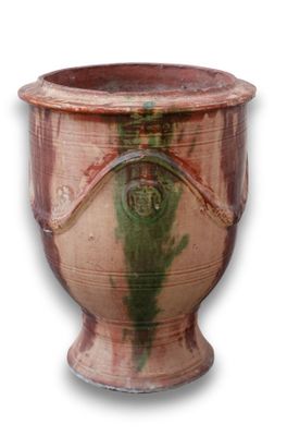 un vase marron avec une anse verte sur fond blanc
