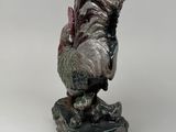 statue of a rooster on a rock on a white background