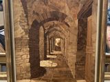 une image représentant un tableau représentant un couloir dans un bâtiment en pierre