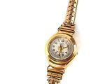 an image of a woman ' s wrist watch with a chain around it