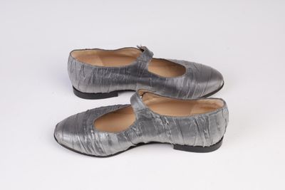une paire de chaussures pour femme posée sur une surface blanche, sur fond blanc