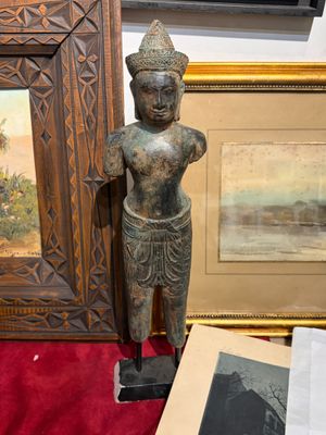 une statue représentant une personne debout à côté d'une photo d'un homme