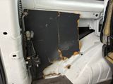 a white van with rust on the door and inside of it