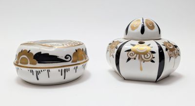 two white and black jars with gold designs on them