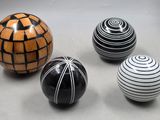 trois balles rayées de noir et blanc posées les unes à côté des autres sur une table
