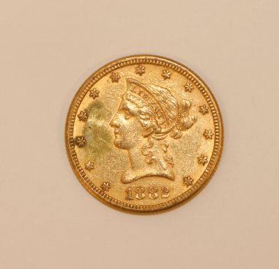 a close up of a gold coin on a white surface