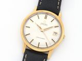 a close up of a watch on a white surface with a black strap