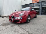la voiture rouge est garée devant un bâtiment dans un parking