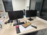a desk with two computer monitors and a phone on it