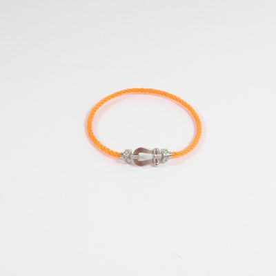 un bracelet en caoutchouc orange avec un fermoir argenté sur fond blanc